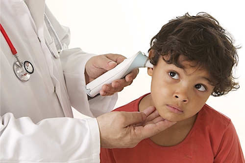 urgent care doctor takes boys temperature by ear