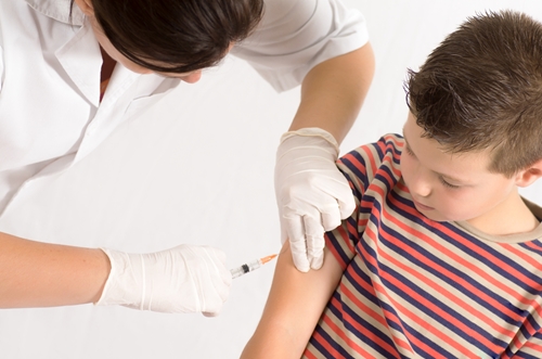 boy gets vaccination shot from doctor