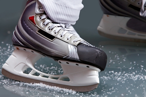 kid wearing hockey blades skates on ice