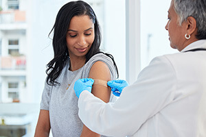 A woman is getting a flu shot from a doctor
