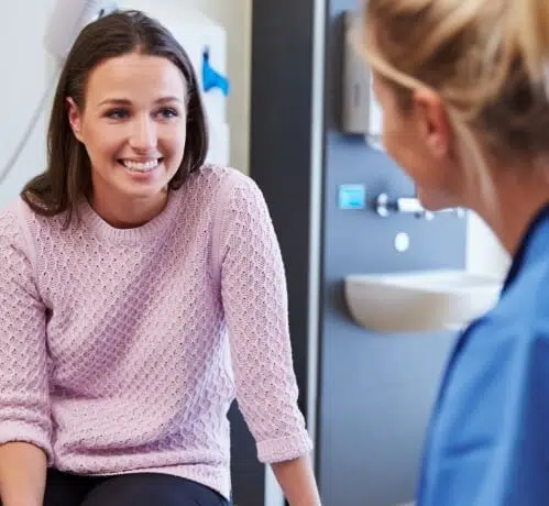 A woman talking to a nurse in a hospital