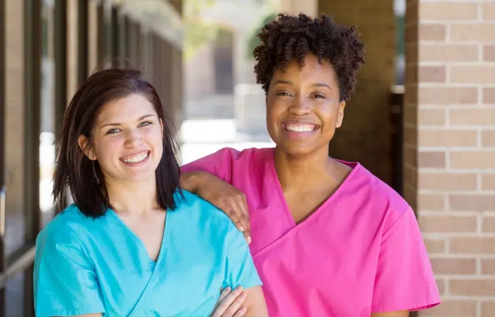Two women in scrubs standing next to each other
